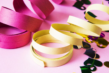 Party decoration. colorful streamers on pink background.