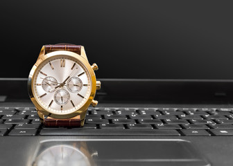 Wrist watch on the laptop keyboard.