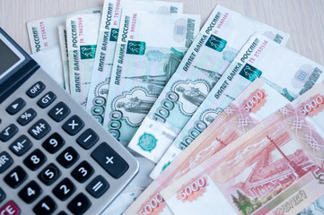 On the table there are money Russian rubles and a calculator. Calculation of profit
