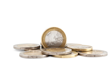 One euro coin on heap of euro coins.