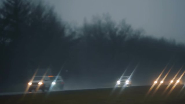 Cars and trucks on highway through windshield window. Rainy day. Late afternoon. Slow motion