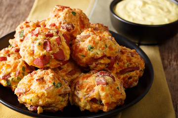 Freshly baked delicious sausage balls with cheese cheddar and greens on a plate close-up. horizontal