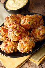 baked sausage balls with cheese cheddar on a plate and mustard sauce close-up. vertical
