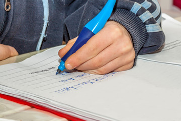 Left handed young doing his homework - Translation: should, can, want, swimming, the word with rr