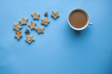 Fototapeta na wymiar A cup of coffee and cookies on blue background.