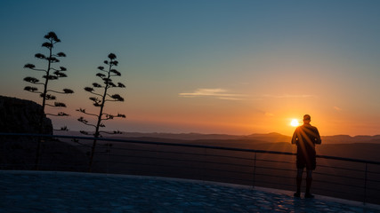 Fototapeta premium Silhouette man who is watching sunset from viewpoint on Gran Canaria island.