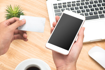 Obraz premium Businessman holding hand credit card and using smartphone.