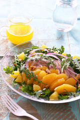 Summer salad with arugula, boiled chicken breast, red onion, and orange 