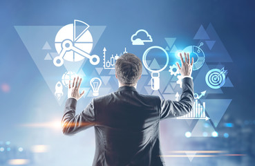 Businessman with hands in the air icons and graphs