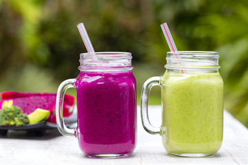 Two glass mugs with fresh smoothies from a dragon fruit, banana, mango, avocado, broccoli and honey. Island Bali, Ubud, Indonesia