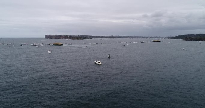 Super maxi sailing boats of Sydney Hobart yacht race clearing from Sydney harbour after start surrounded by spectator boasts and passenger ships.
