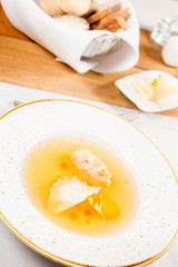 Dumplings in broth with an egg yolk served in a restaurant
