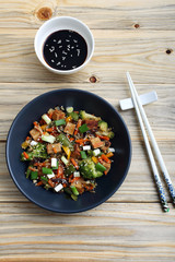 insalata di tofu con verdure e legumi al forno su sfondo tavolo di cucina