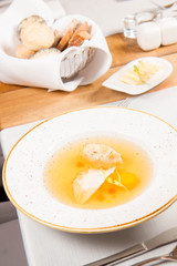 Dumplings in broth with an egg yolk served in a restaurant