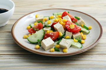 insalata vegetariana con tufu pomodori cetrioli e mais su tavolo di cucina