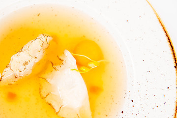 Naklejka na ściany i meble Dumplings in broth with an egg yolk on a white background