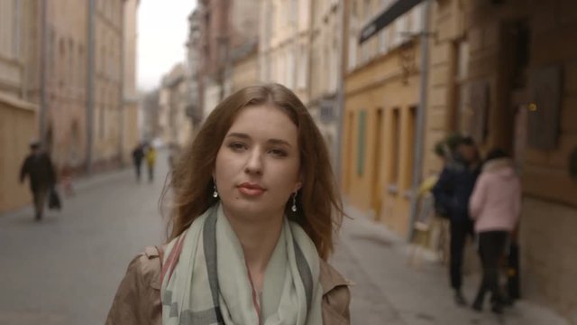 Attractive woman goes along street of the old city