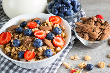 Healthy breakfast concept with oat flakes and fresh berries on rustic background. Food made of granola, muesli. Healthy banana smoothie with blackberries, muslie, strawberries, blueberries and honey.