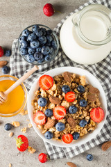 Healthy breakfast concept with oat flakes and fresh berries on rustic background. Food made of granola, muesli. Healthy banana smoothie with blackberries, muslie, strawberries, blueberries and honey.