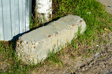 Concrete pile lying on the ground near the fence