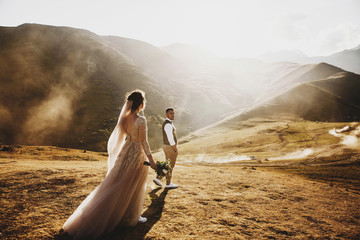 Stylish young wedding couple has fun posing in beautiful Georgian mountains