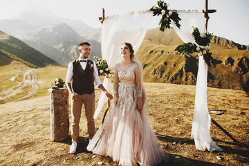 Bride and groom look lovely during the wedding ceremony on the top of the mountain somewhere in...