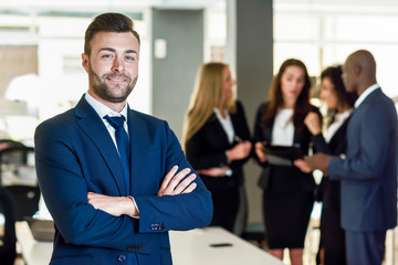 Businessman leader in modern office with businesspeople working at background