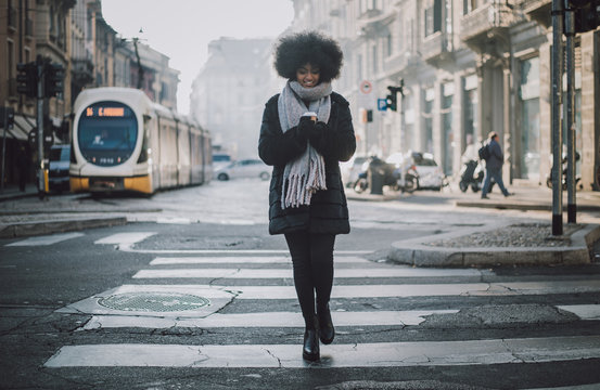 Beautiful girl with afro haircut walking on the street