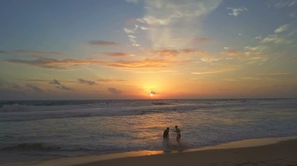 Girl couple playing with baby at beach wonderful sunset drone footage