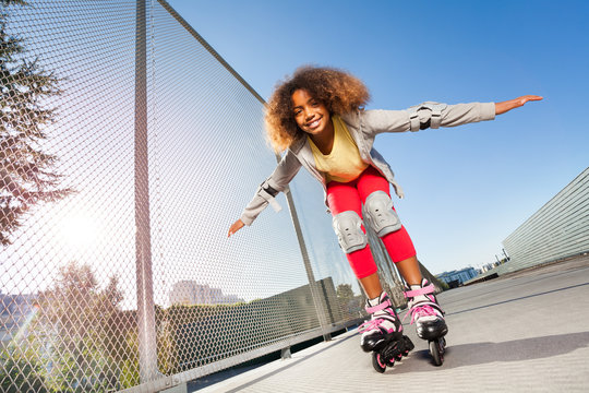 Active African girl rollerblading at skate park