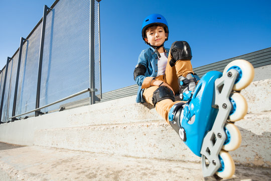 Roller boy resting on the steps of skate park