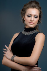 fashion portrait of Beauty Looks woman model with  brown hair fresh skin wearing accessories and jewelry isolated over dark blue background