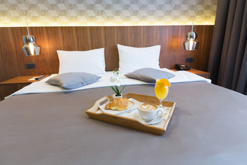 Breakfast in bed, hotel bedroom interior