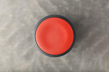 Overhead of Red Circular Push Button Over Blurred Gray Background