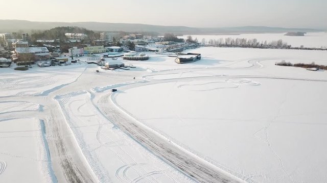 One Car Driving Through The Winter Forest On Country Road. Top View From Drone. Aerial View Of Snow Covered Road In Winter, Car Passing By. Top View Of The Car Traveling On Snowy Road