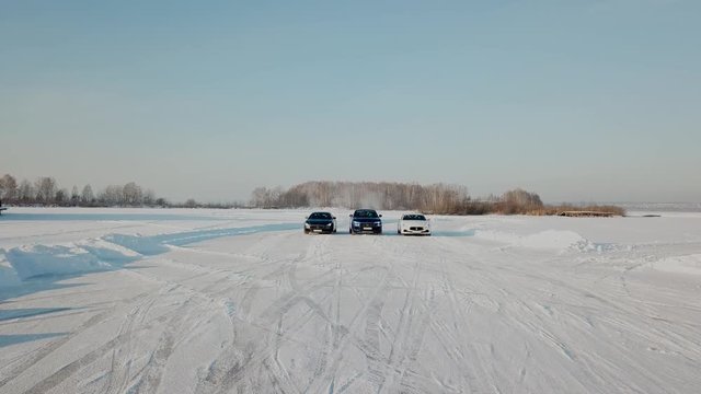 Three Cars stopped in snow road. ars parked on snowy road. Cars ready to race standing on a snowy road