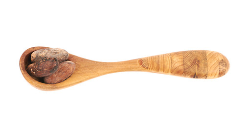 Wooden spoon of cocoa beans isolated