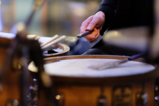 The musician's hand during performance of a composition on a drum set