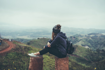 Young woman traveler sitting and looking view of nature