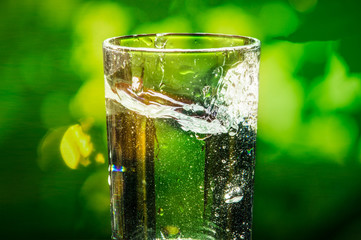 glass with water splash and blurred background