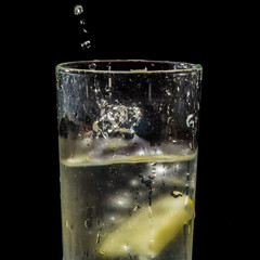 Fototapeta na wymiar water splash with lemon and ice on black