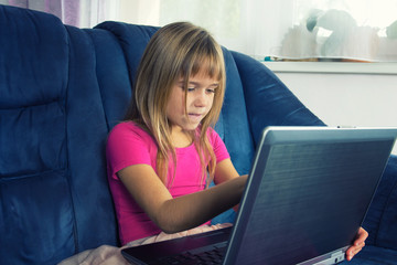 Little girl sitting at the computer.