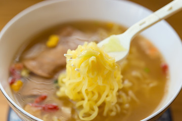 eating instant noodles with sauce and luncheon meat close up