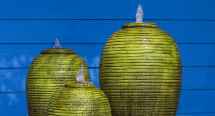 Green fountain jar and blue walls peaceful.