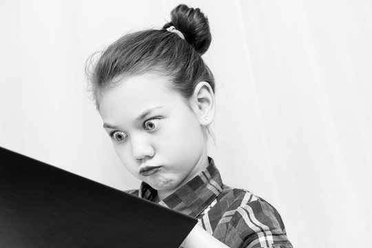 Beautiful Child Rolling His Eyes And Puffing Out His Cheeks Looking At The Book