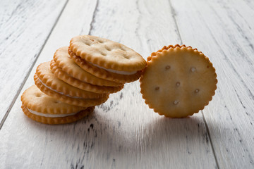 sandwich biscuits with white cream filling on white wood background