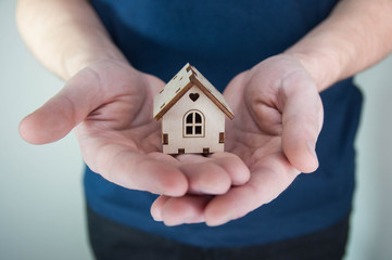 Man holding in hands little toy home