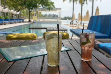 Summer drinks at a pool with ice and straw