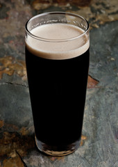 Glass of stout beer top with white foam