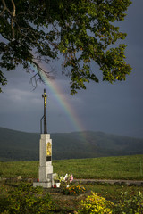 God's torture under a tree on a hill and a rainbow after rain